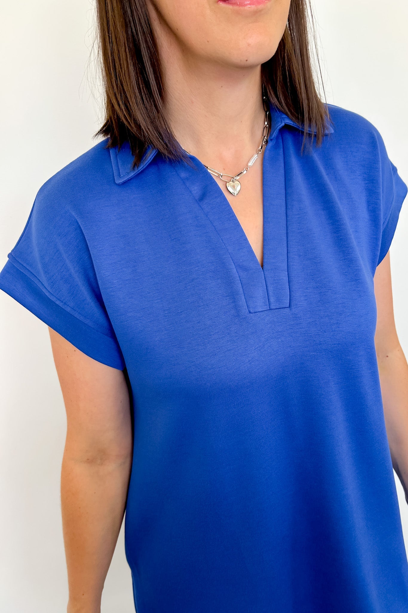 Person wearing a blue short-sleeve top with a white background