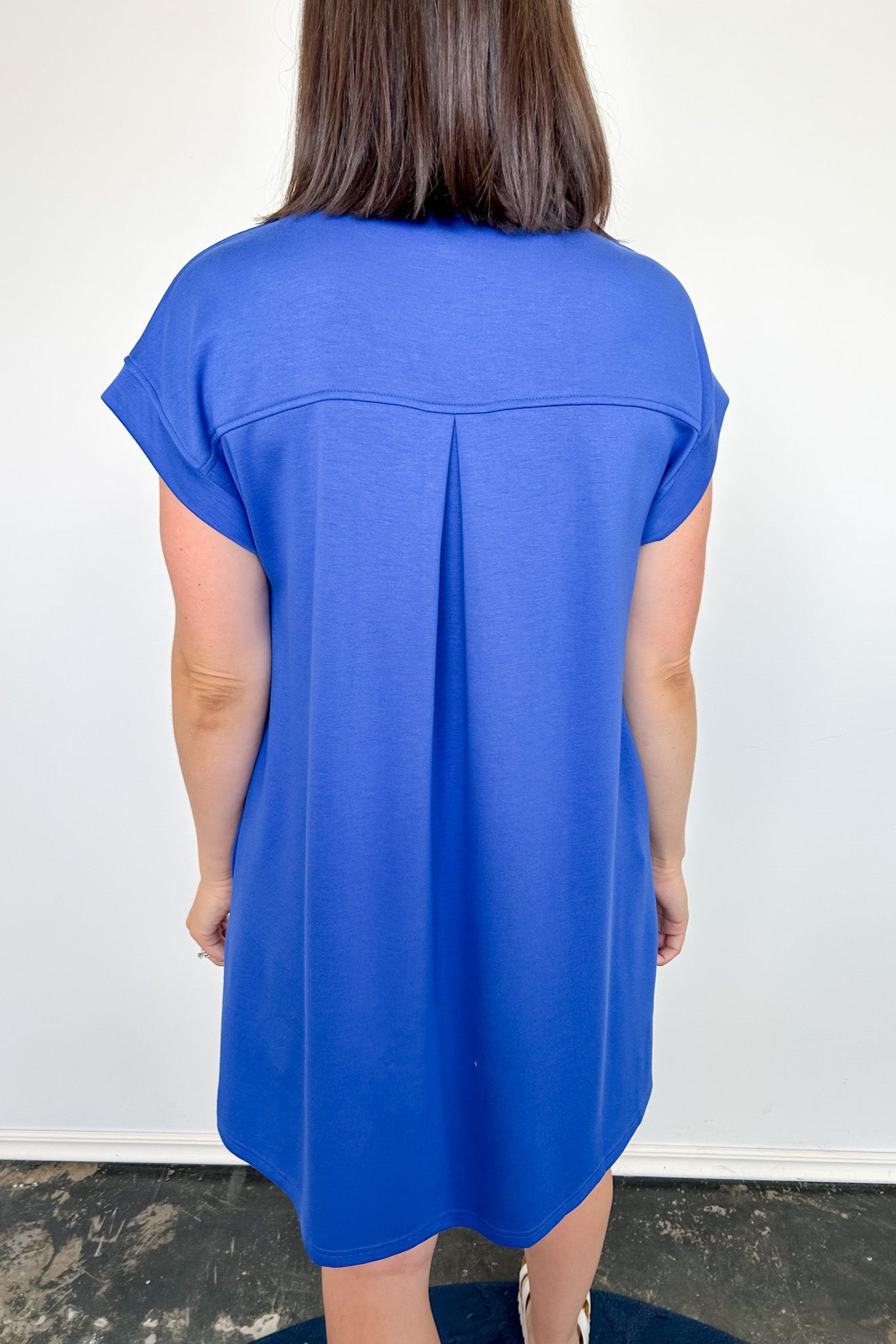 Person wearing a blue dress against a white background