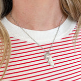 Person wearing a red and white striped shirt with a necklace
