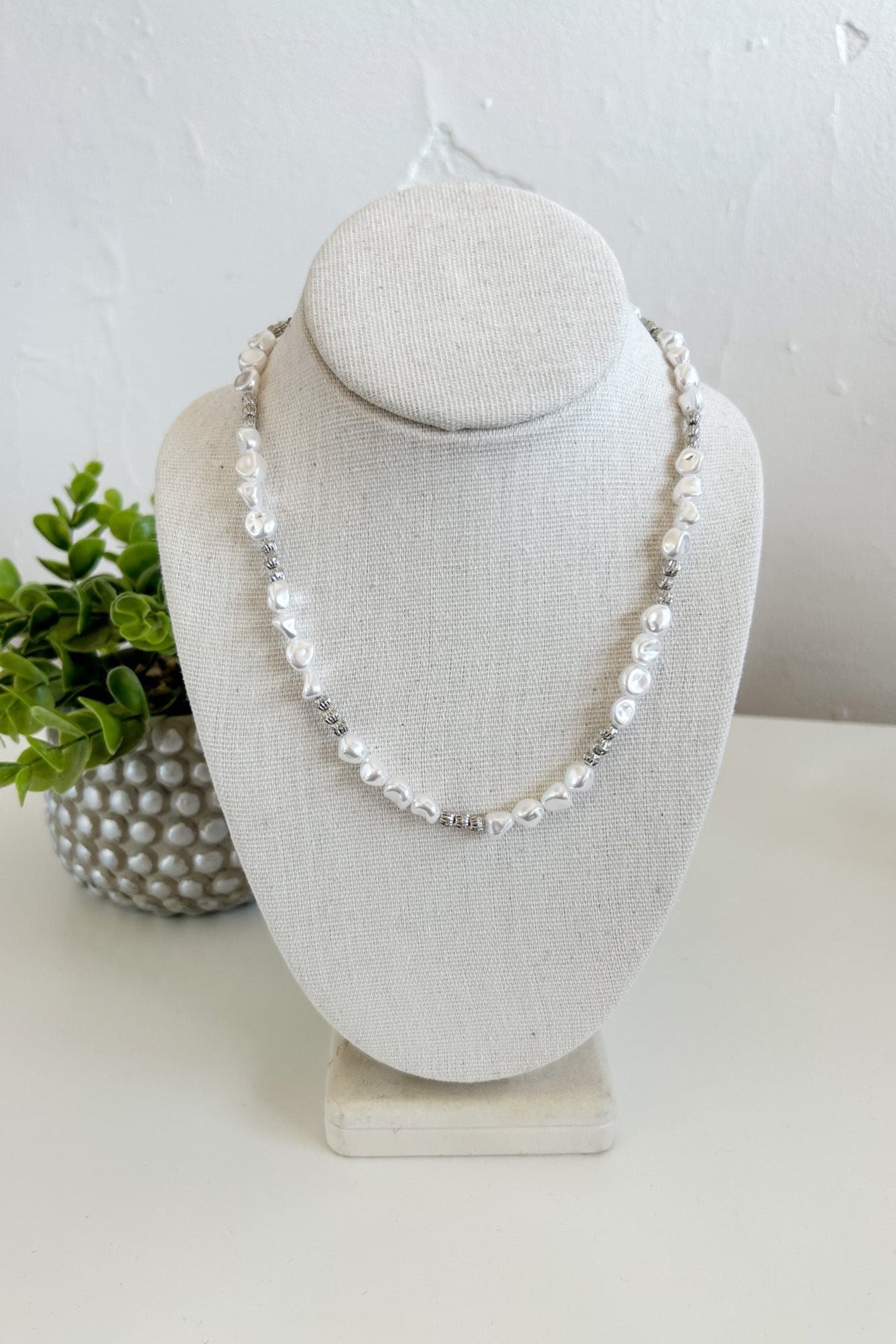 Pearl necklace on a white bust with a white background