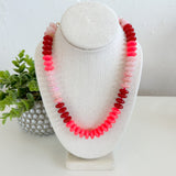 Necklace with multicolored beads on a white bust against a white background