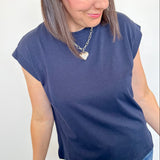 Woman wearing a blue t-shirt and jeans against a white background