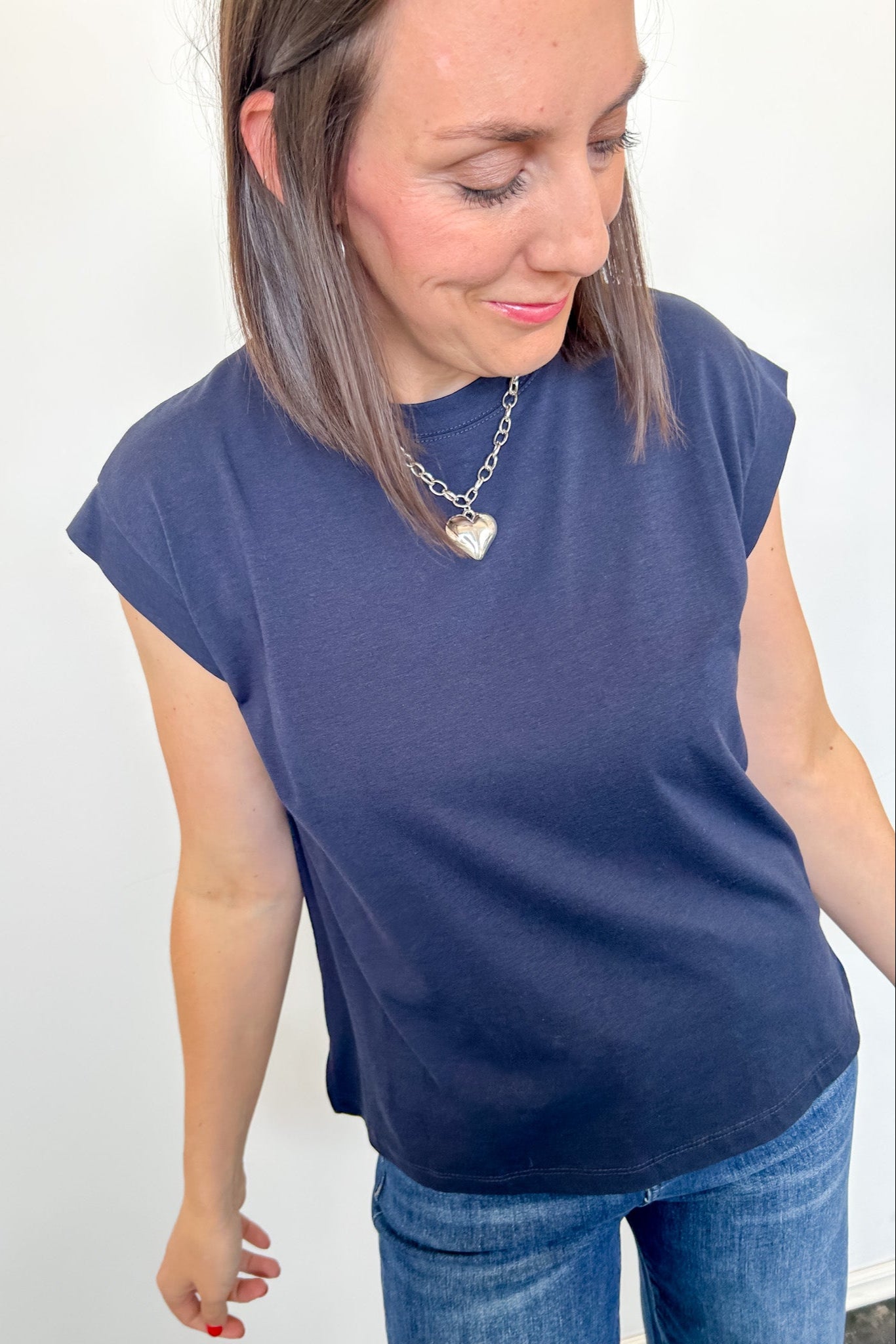 Woman wearing a blue t-shirt and jeans against a white background