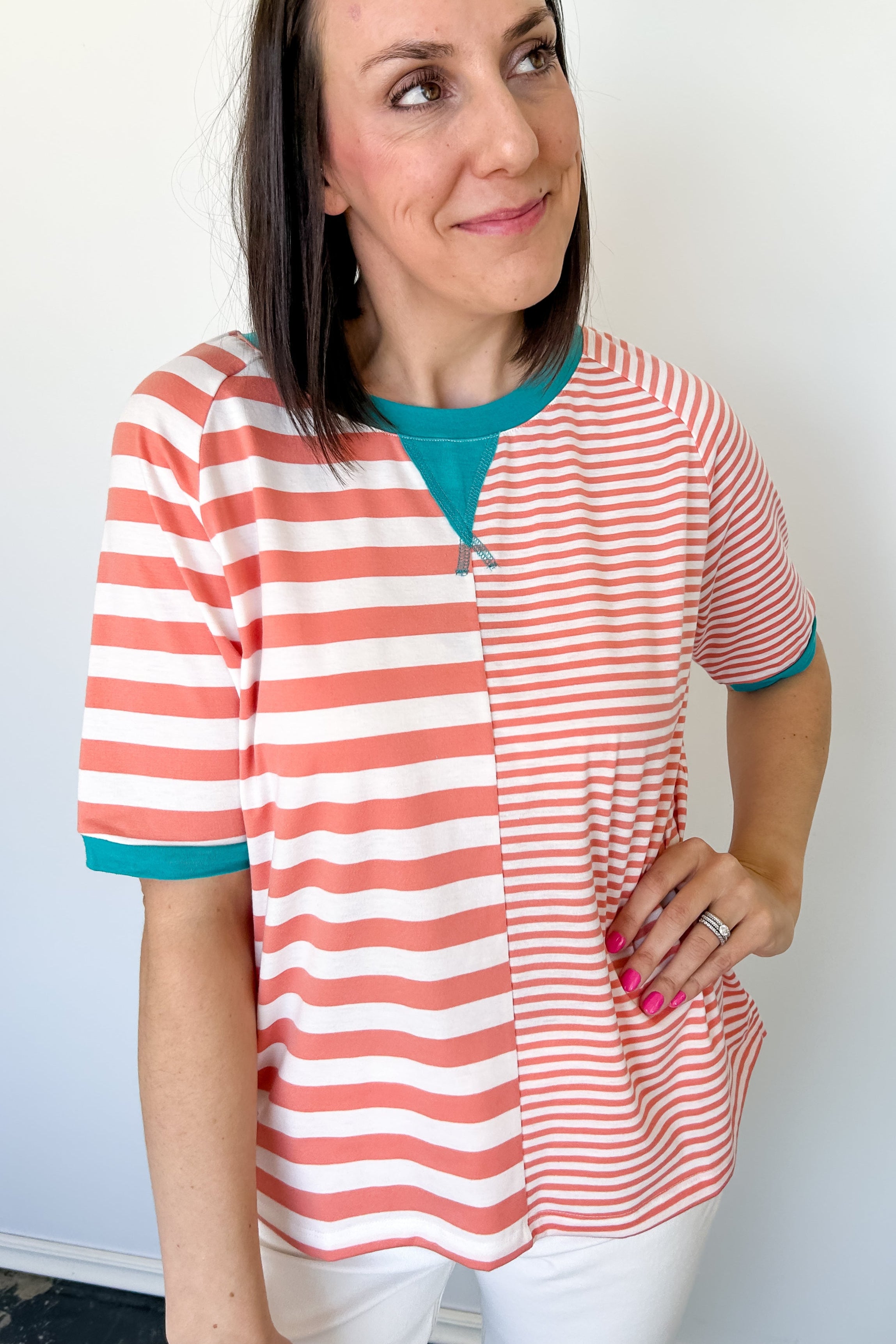 Photo of model wearing a peach and white striped shirt with half length sleeves