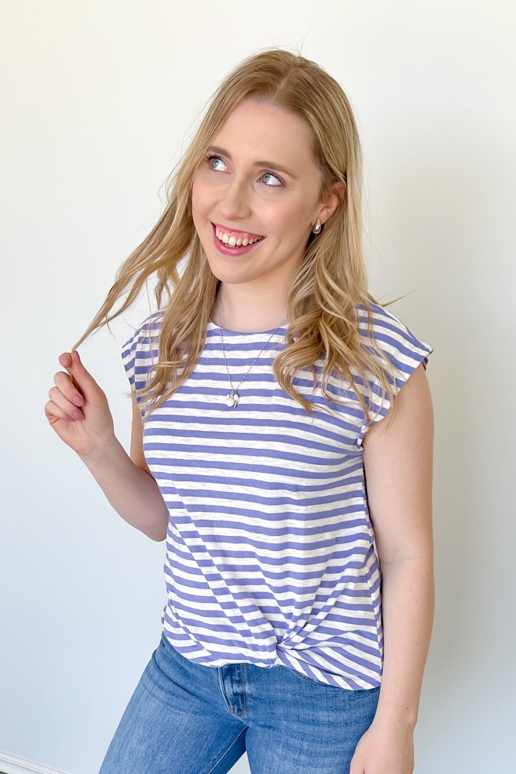 Photo of model wearing a striped top with twisted hem and cap sleeves