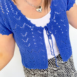 Photo of model wearing a crochet, cobalt blue, crop cardigan