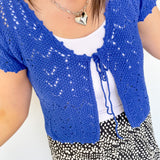 Photo of model wearing a crochet, cobalt blue, crop cardigan