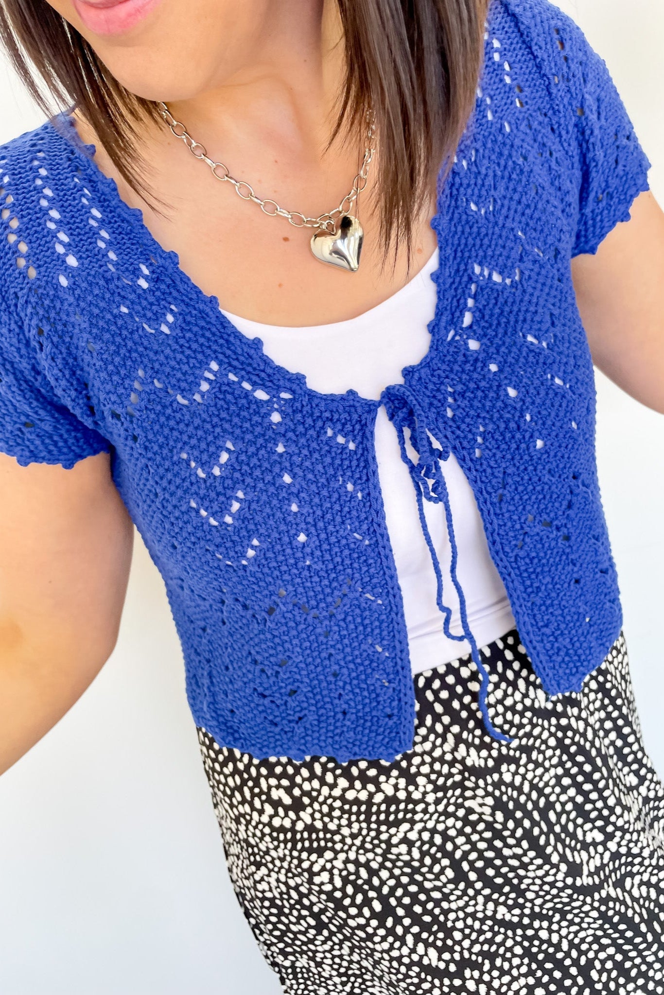 Photo of model wearing a crochet, cobalt blue, crop cardigan