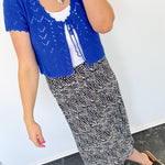 Photo of model wearing a black midi skirt with an abstract white dot patter