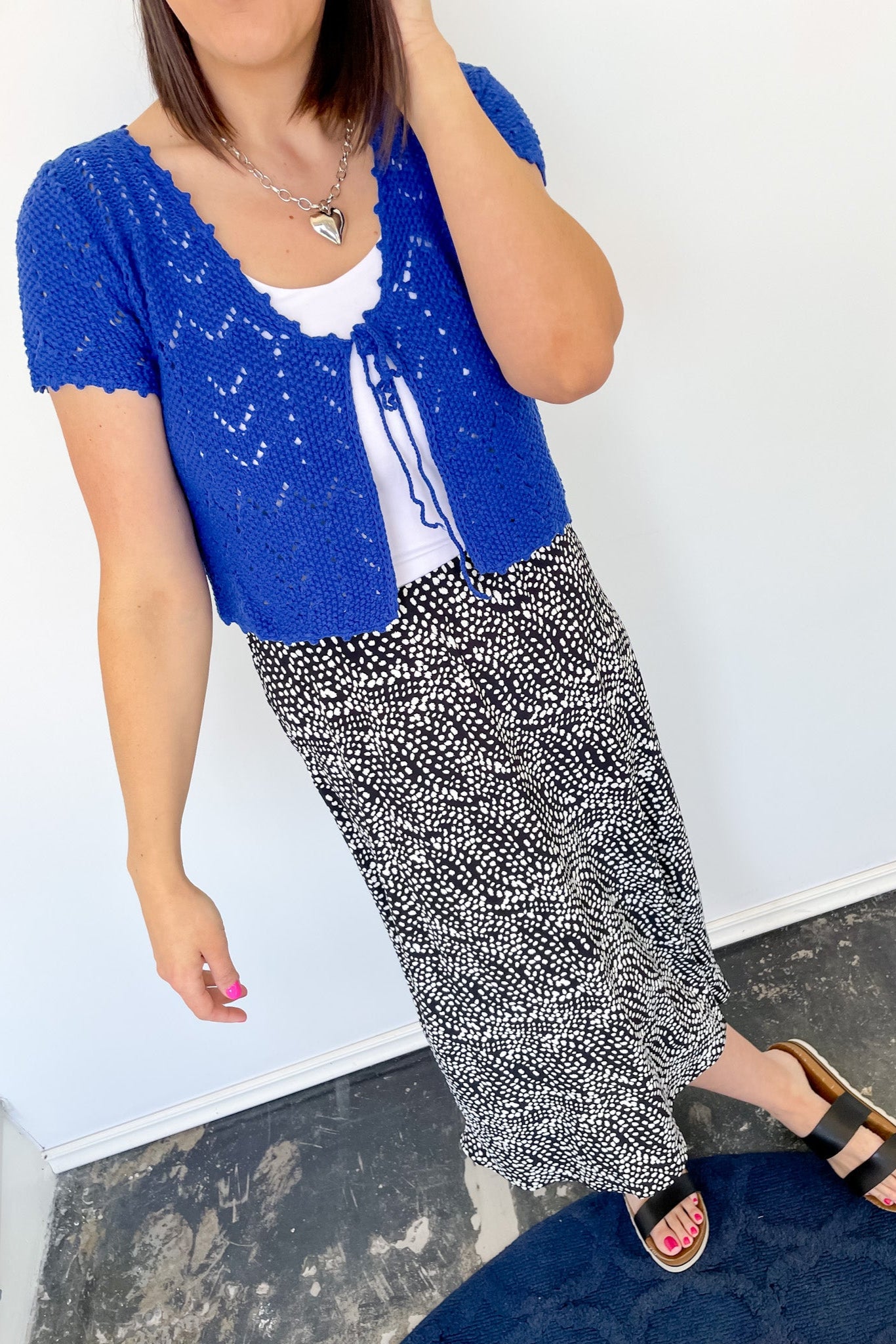 Photo of model wearing a black midi skirt with an abstract white dot patter