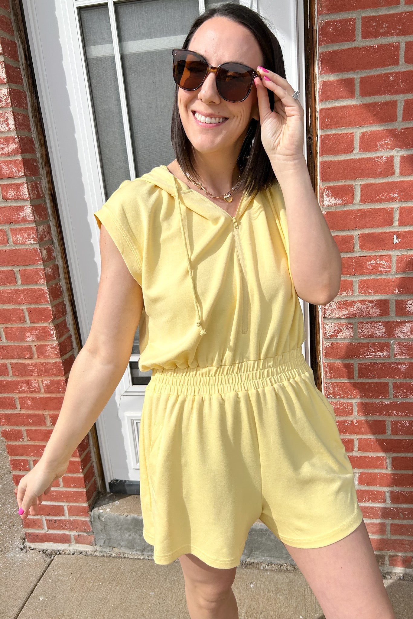 Hooded romper with stretchy waistband. Zipper front. Pockets. Short sleeve.