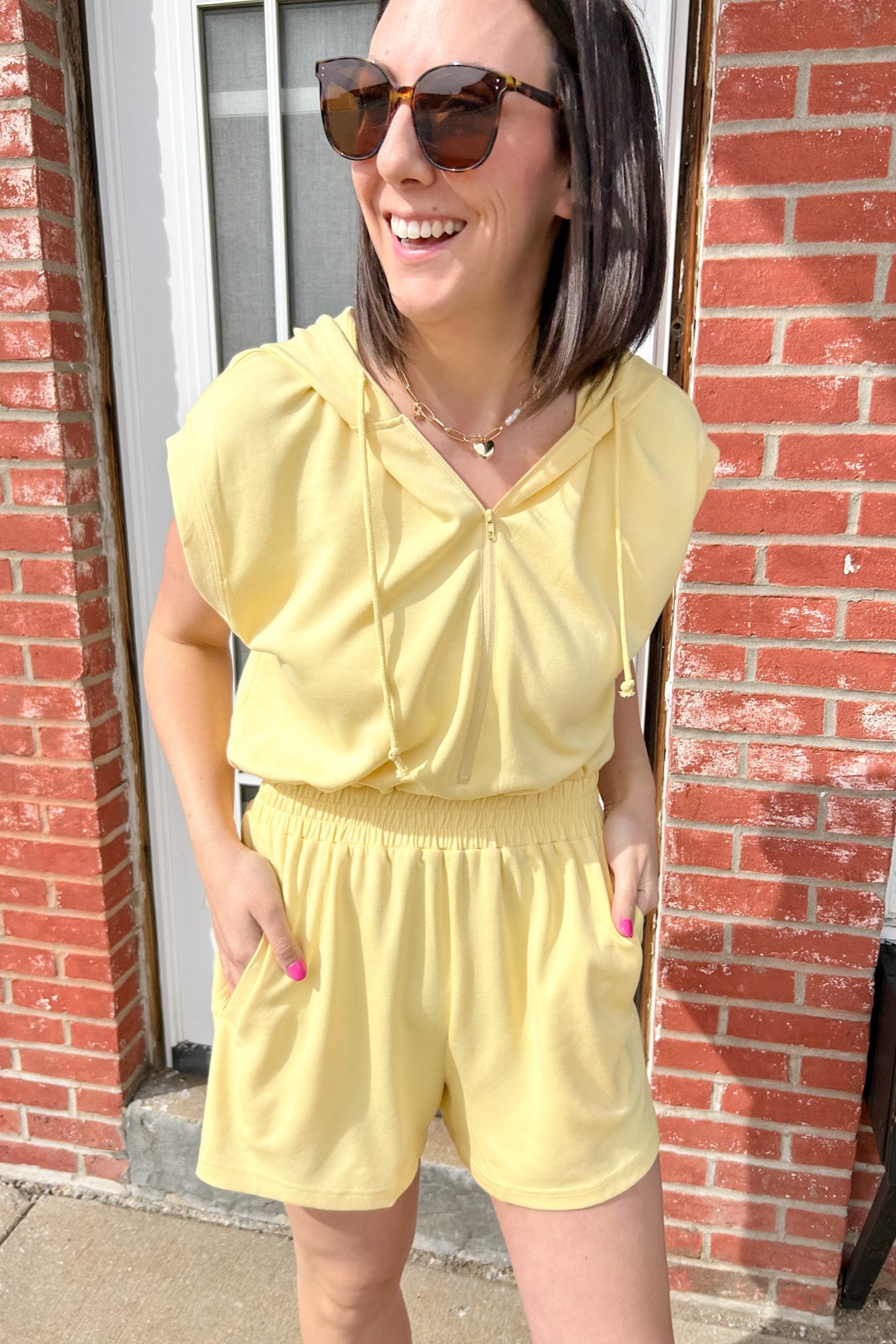 Hooded romper with stretchy waistband. Zipper front. Pockets. Short sleeve.