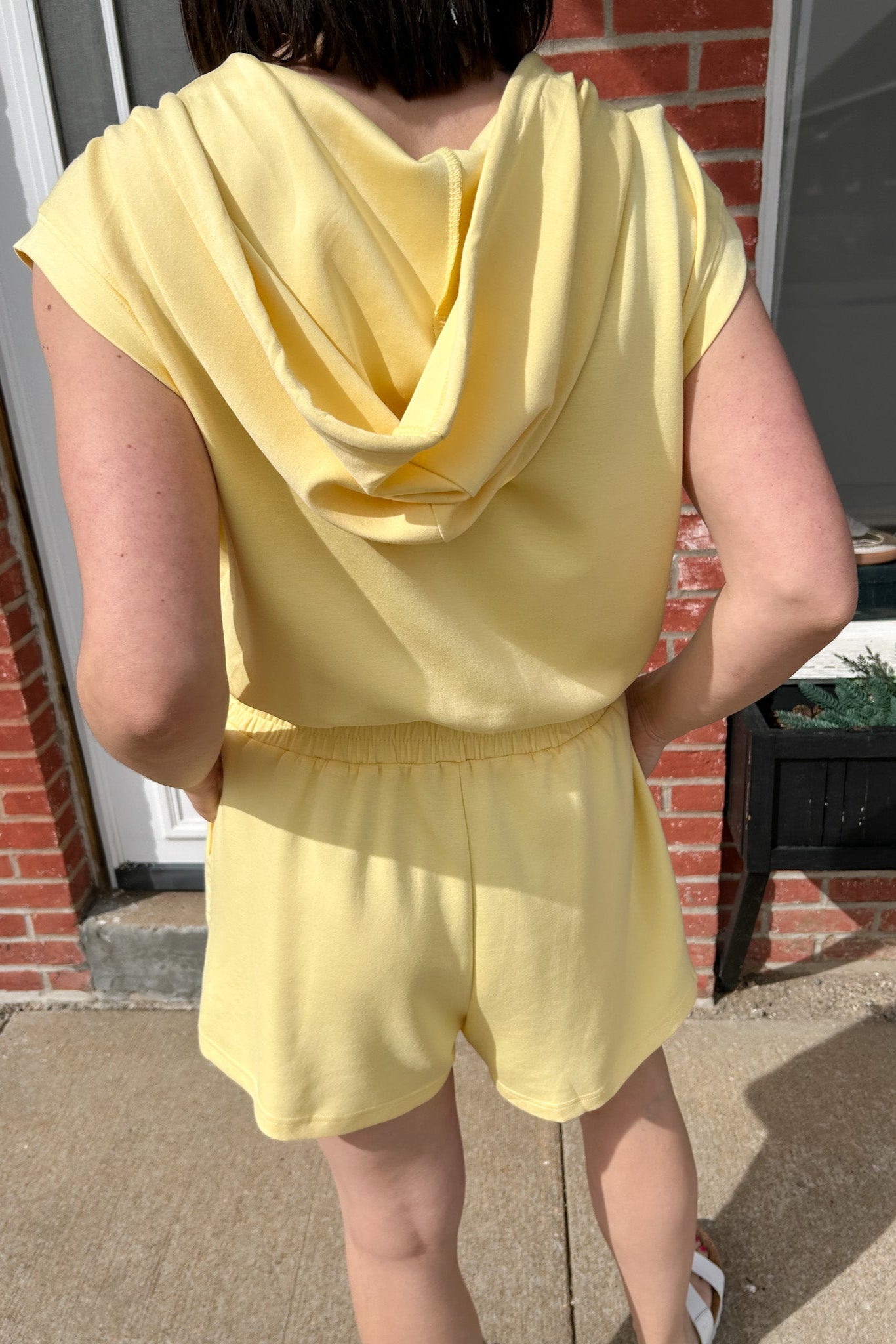 Hooded romper with stretchy waistband. Zipper front. Pockets. Short sleeve.