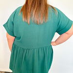 Person wearing a green blouse with a plain white background
