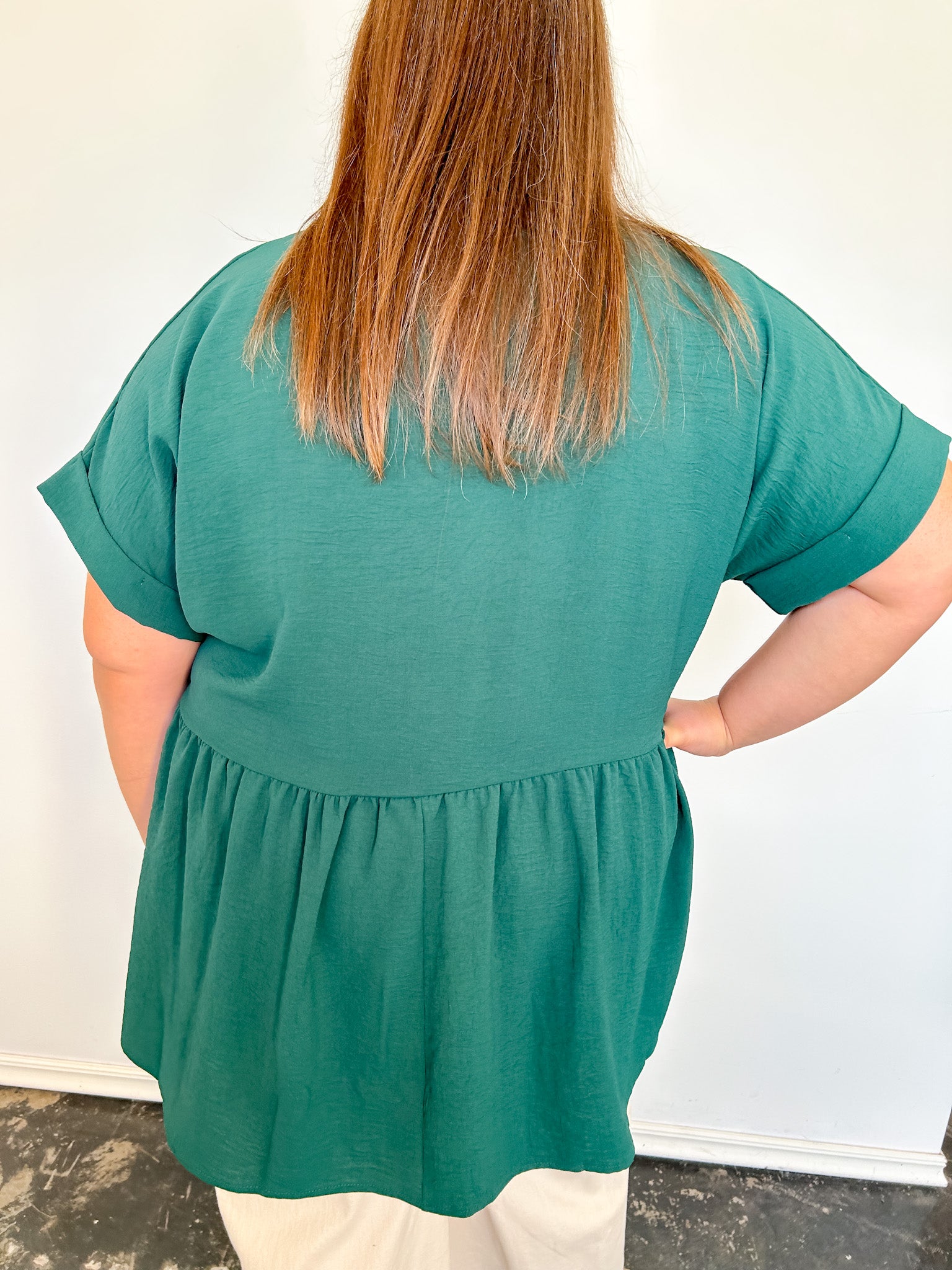 Person wearing a green blouse with a plain white background