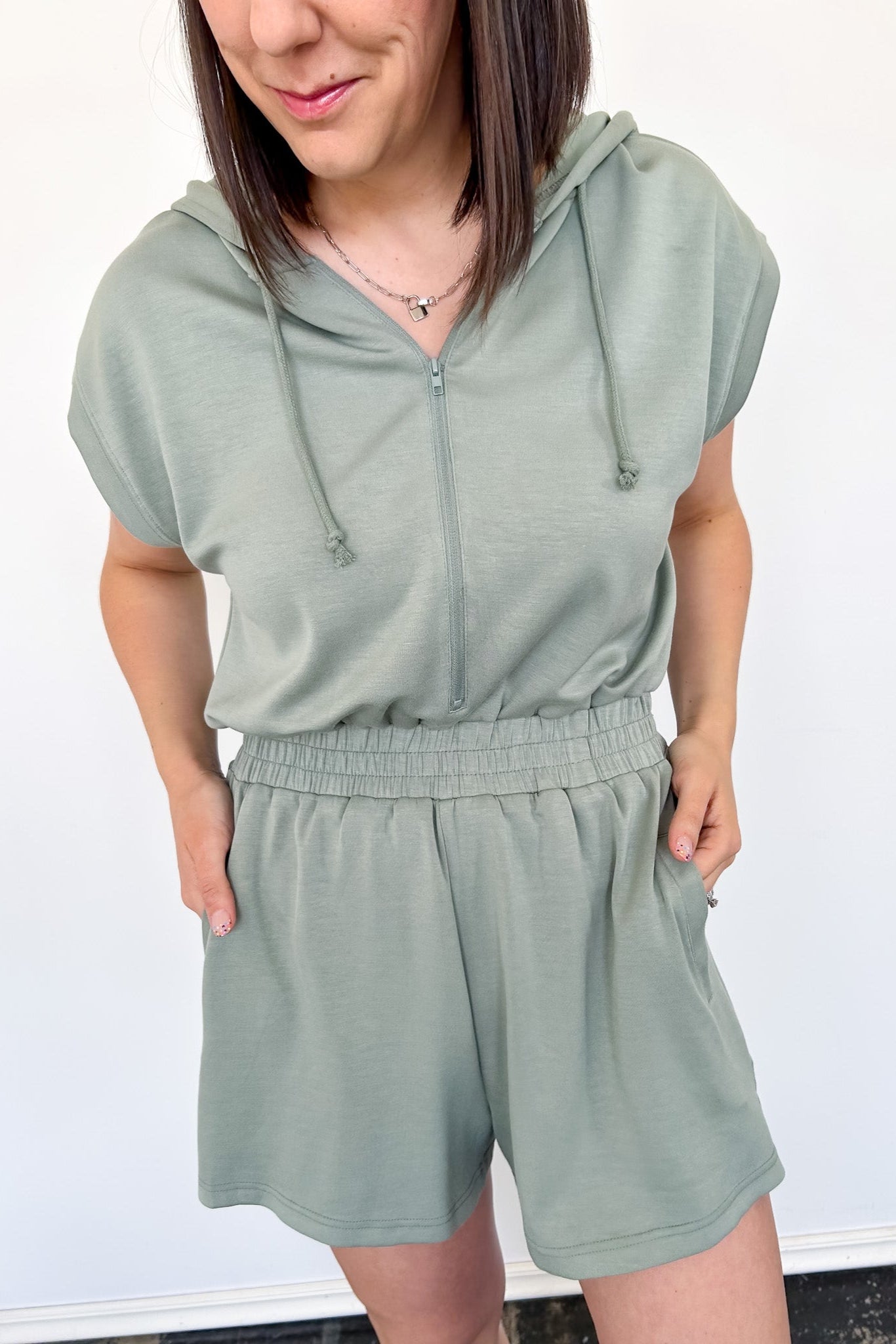 Hooded romper with stretchy waistband. Zipper front. Pockets. Short sleeve.