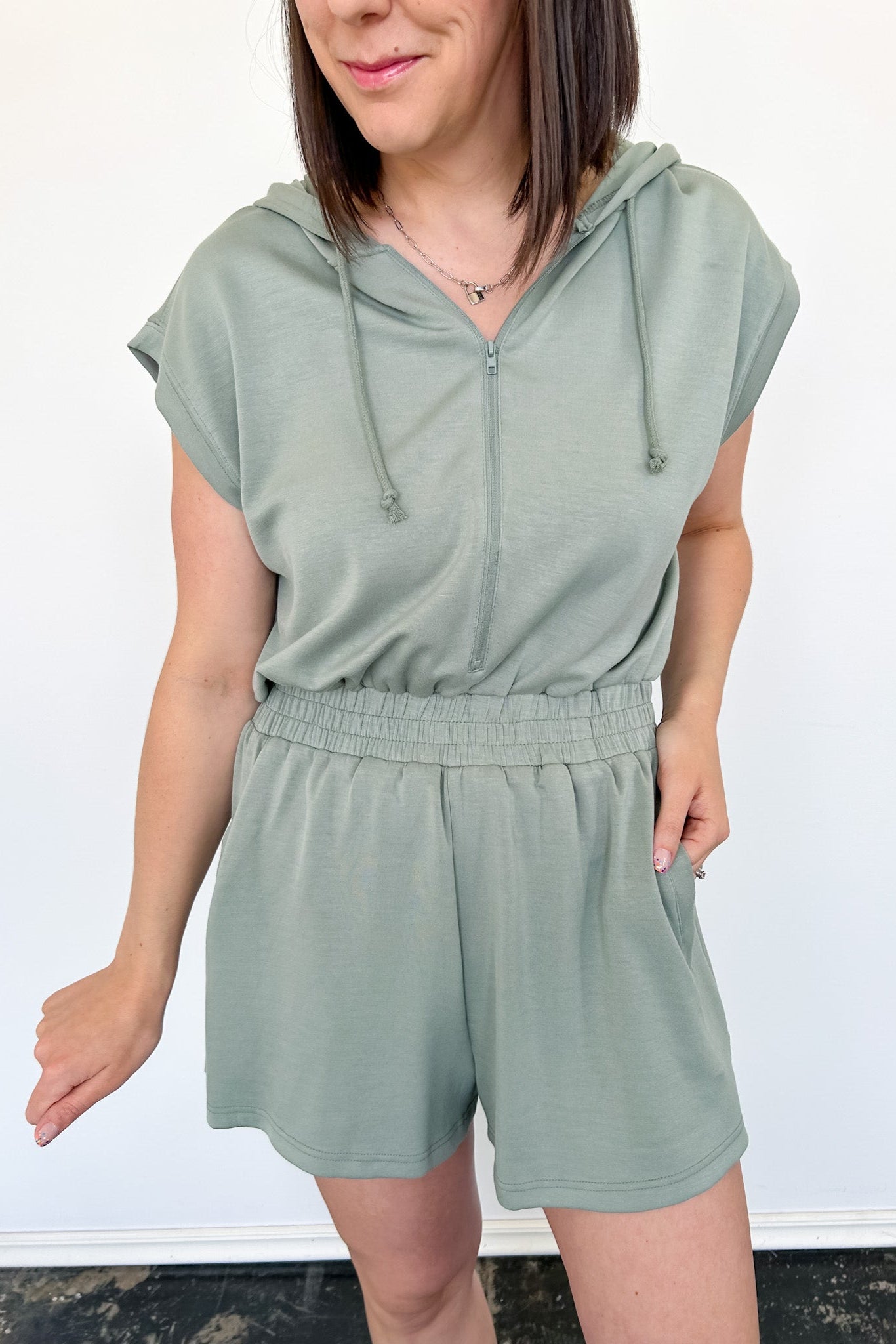Hooded romper with stretchy waistband. Zipper front. Pockets. Short sleeve.
