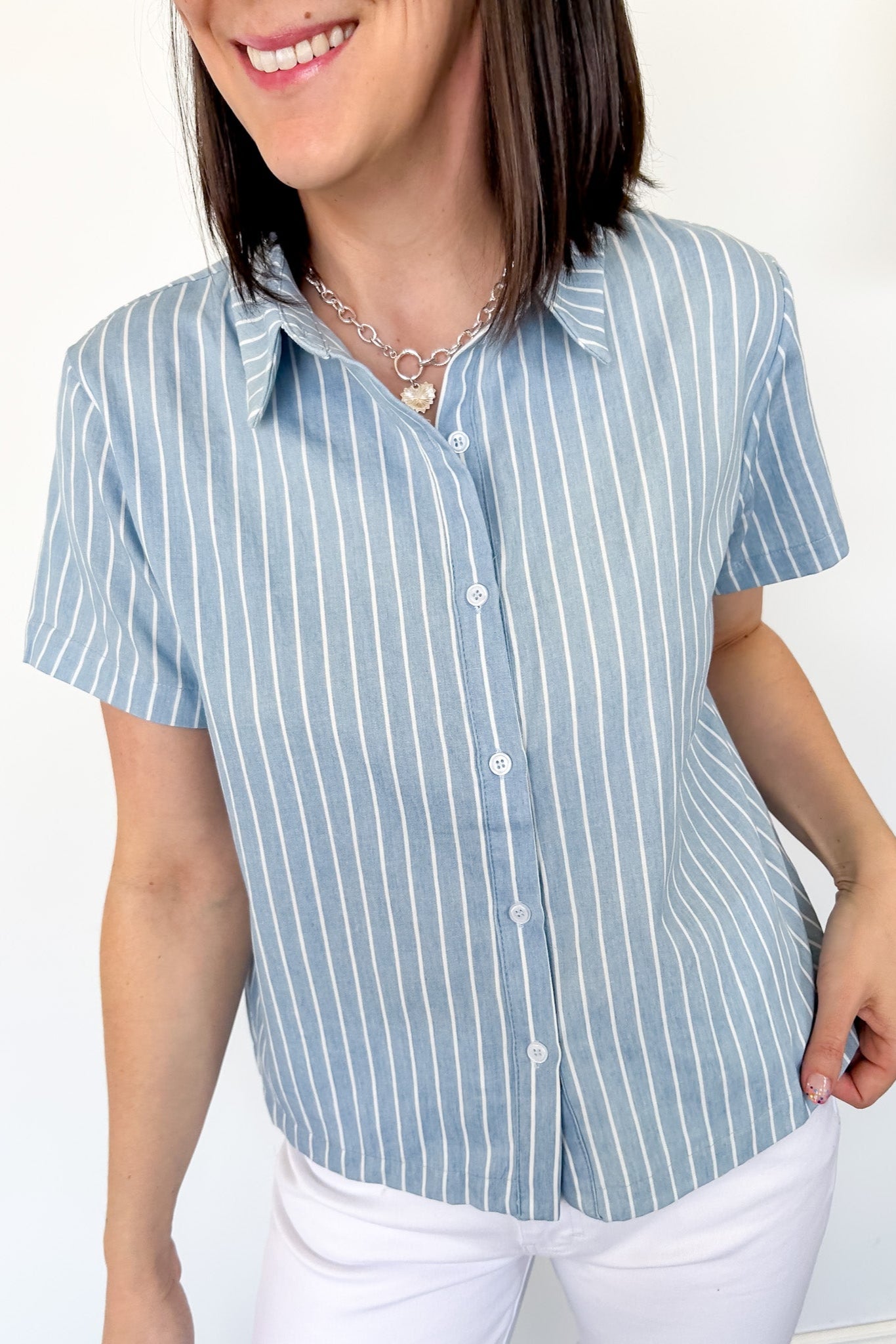 Light blue collared button up top with white stripe details. Short sleeve. 
