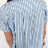 Light blue collared button up top with white stripe details. Short sleeve. 