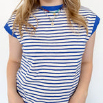 A person wearing a light blue and white striped collared button-up top with short sleeves.