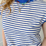 Blue and white striped top with necklaces.