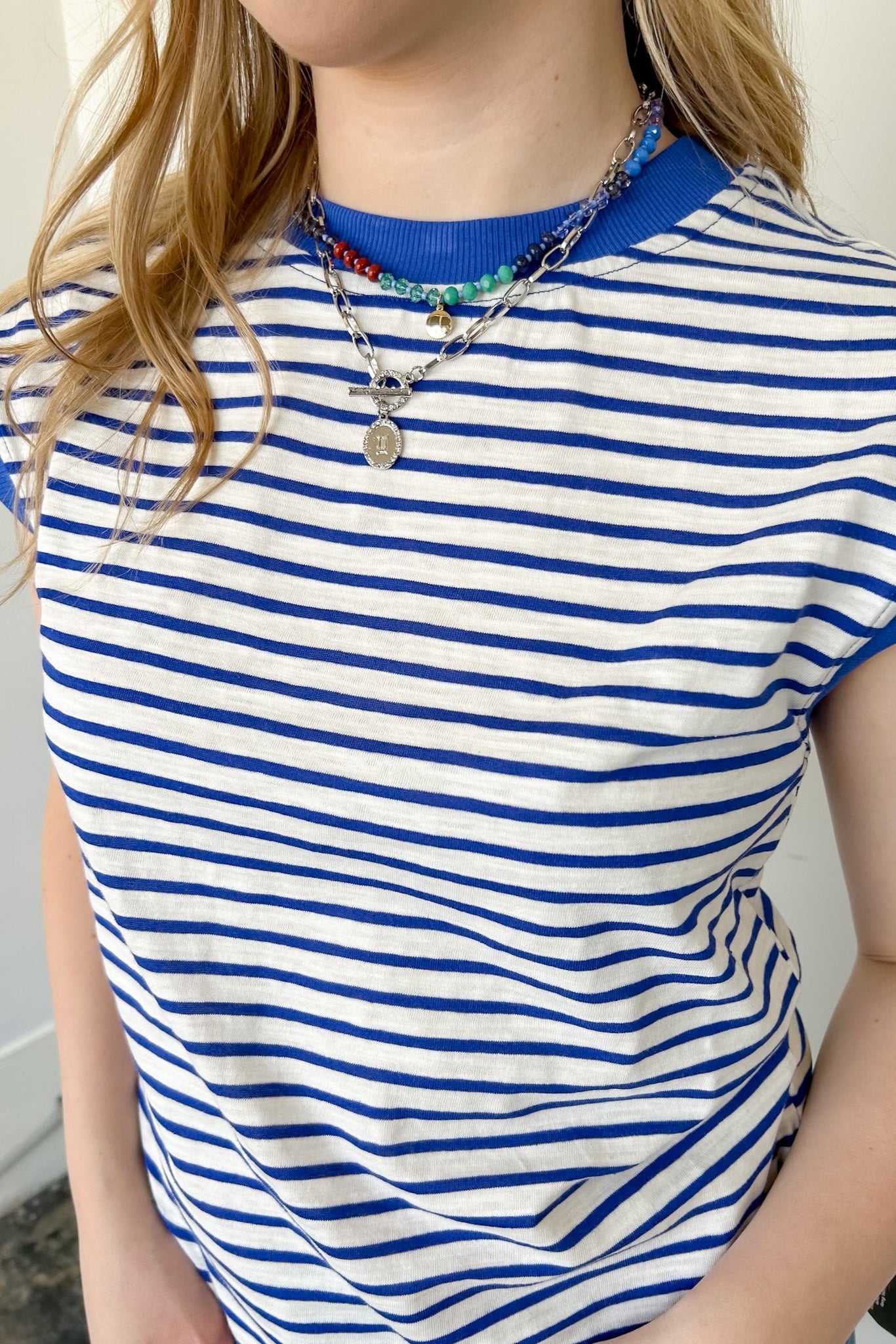 Blue and white striped top with necklaces.