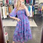 Flowy floral print dress with colors periwinkle and hot pink. Smocked bodice. Puff sleeves with tiered bottom. 