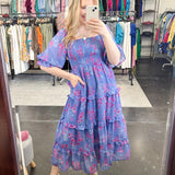 Flowy floral print dress with colors periwinkle and hot pink. Smocked bodice. Puff sleeves with tiered bottom. 