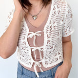 White crochet cropped sweater with three ties in the front. Perfect for layering over a tank or dress.
