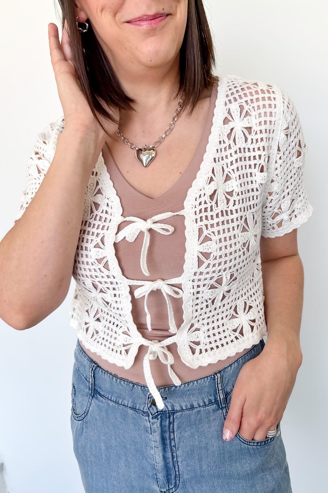White crochet cropped sweater with three ties in the front. Perfect for layering over a tank or dress.