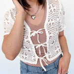 White crochet cropped sweater with three ties in the front. Perfect for layering over a tank or dress.