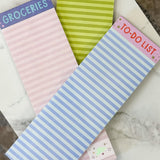 Four small notepads with different designs and text on a marble surface.