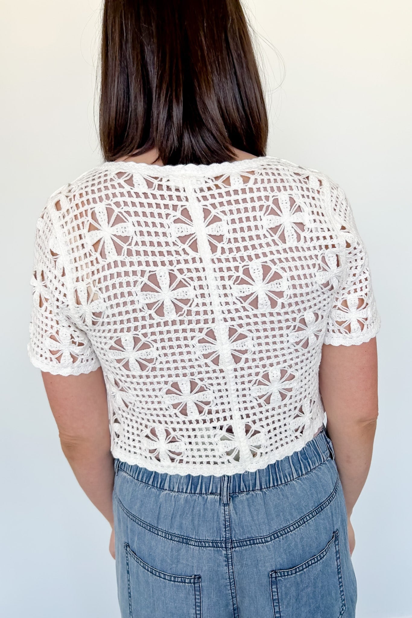 White crochet cropped sweater with three ties in the front. Perfect for layering over a tank or dress.