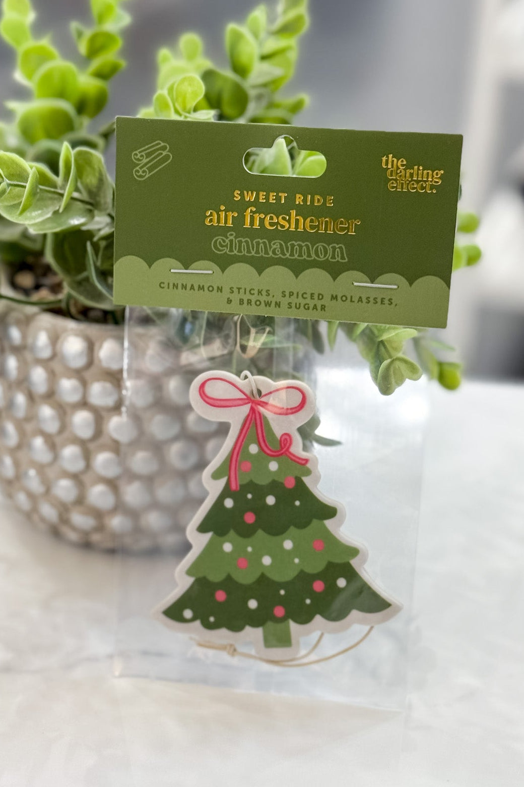 Christmas-themed air freshener with a tree design on a white surface.