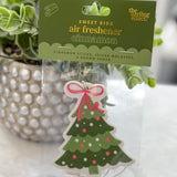 Christmas-themed air freshener with a tree design on a white surface.