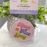 Air freshener with a plant and 'Have a Nice Day' tag on a marble surface