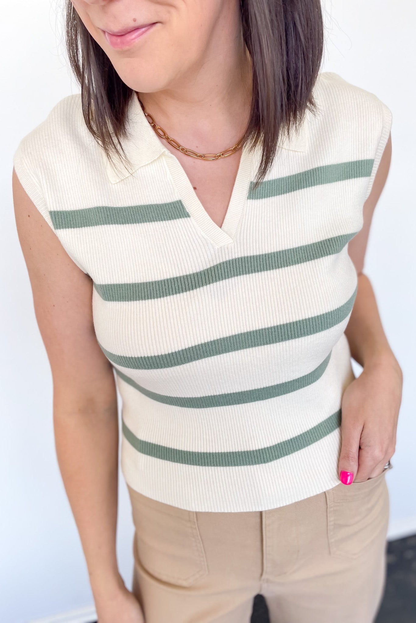 Sweater tank with collar and small v neckline. Cream with olive horizontal stripes. Regular fit. 