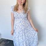 Floral print midi length dress. Blue and white in color. V neckline with flowy bottom and ruffles short sleeves.