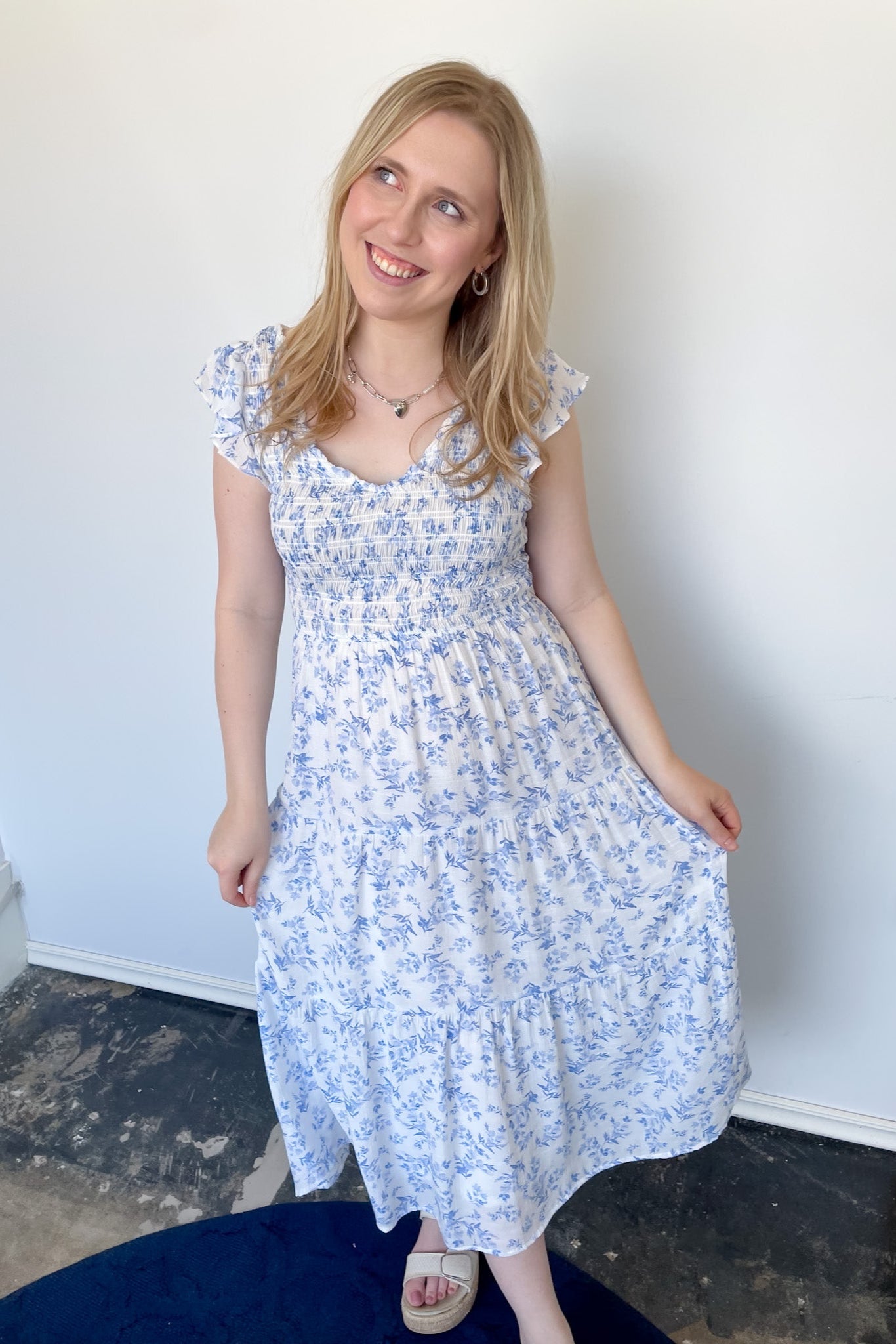 Floral print midi length dress. Blue and white in color. V neckline with flowy bottom and ruffles short sleeves.