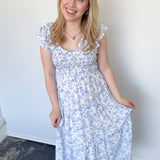 Floral print midi length dress. Blue and white in color. V neckline with flowy bottom and ruffles short sleeves.