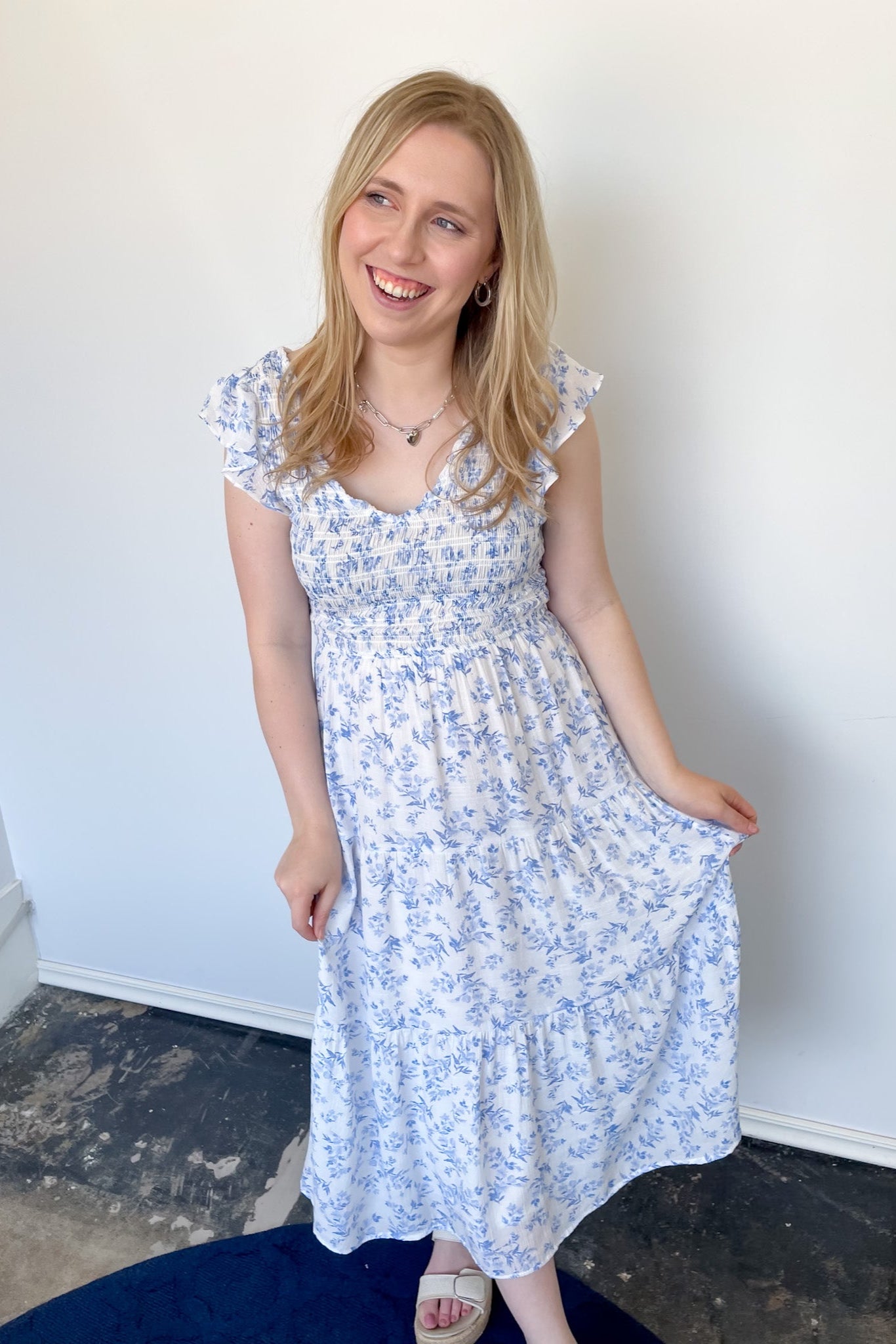 Floral print midi length dress. Blue and white in color. V neckline with flowy bottom and ruffles short sleeves.