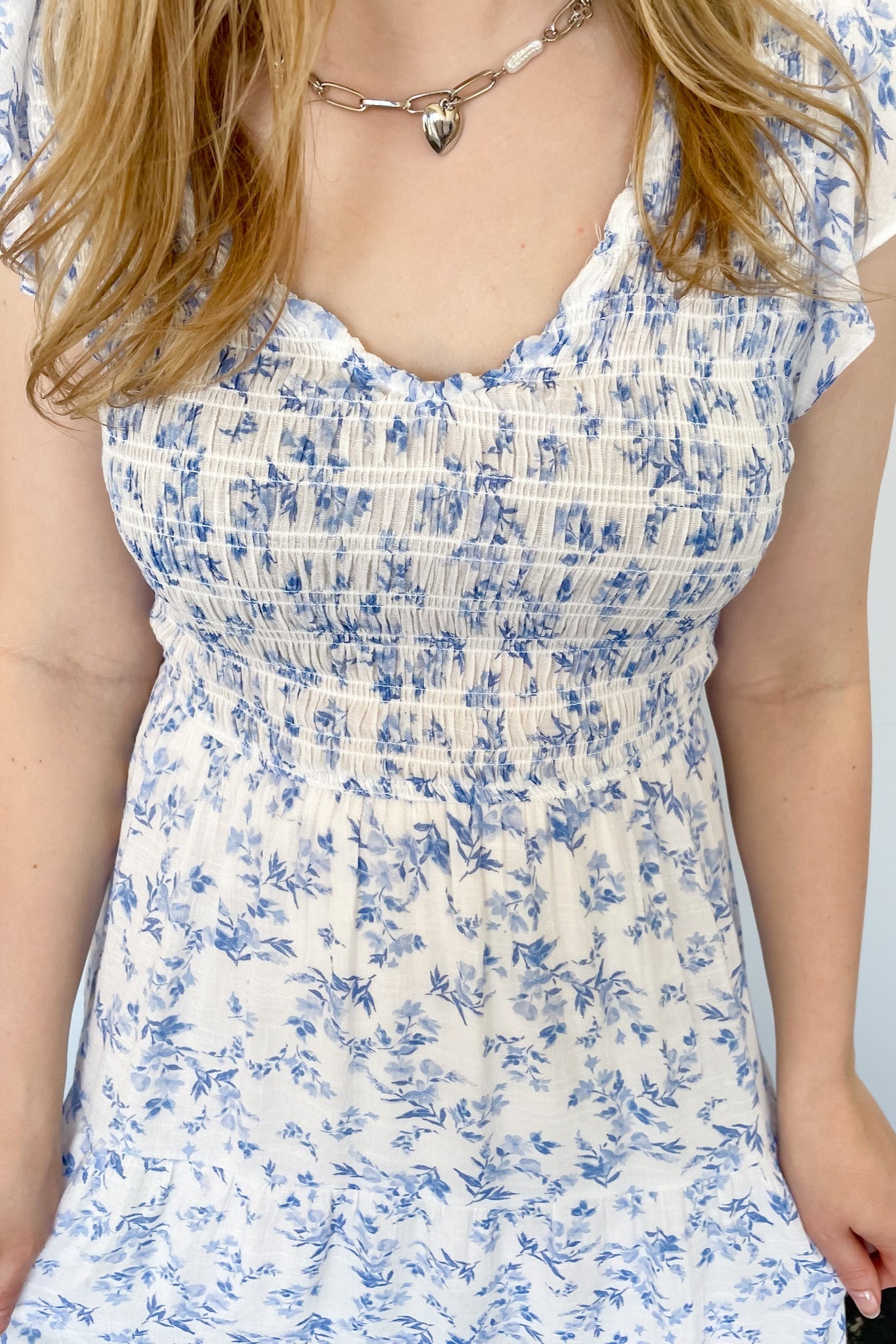 Floral print midi length dress. Blue and white in color. V neckline with flowy bottom and ruffles short sleeves.
