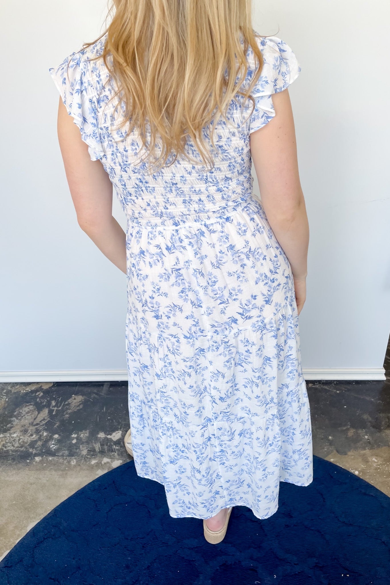 Floral print midi length dress. Blue and white in color. V neckline with flowy bottom and ruffles short sleeves.