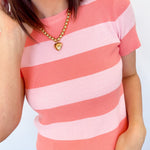 Pink and coral toned striped sweater. High neckline. Slightly cropped fit. Short sleeve style.