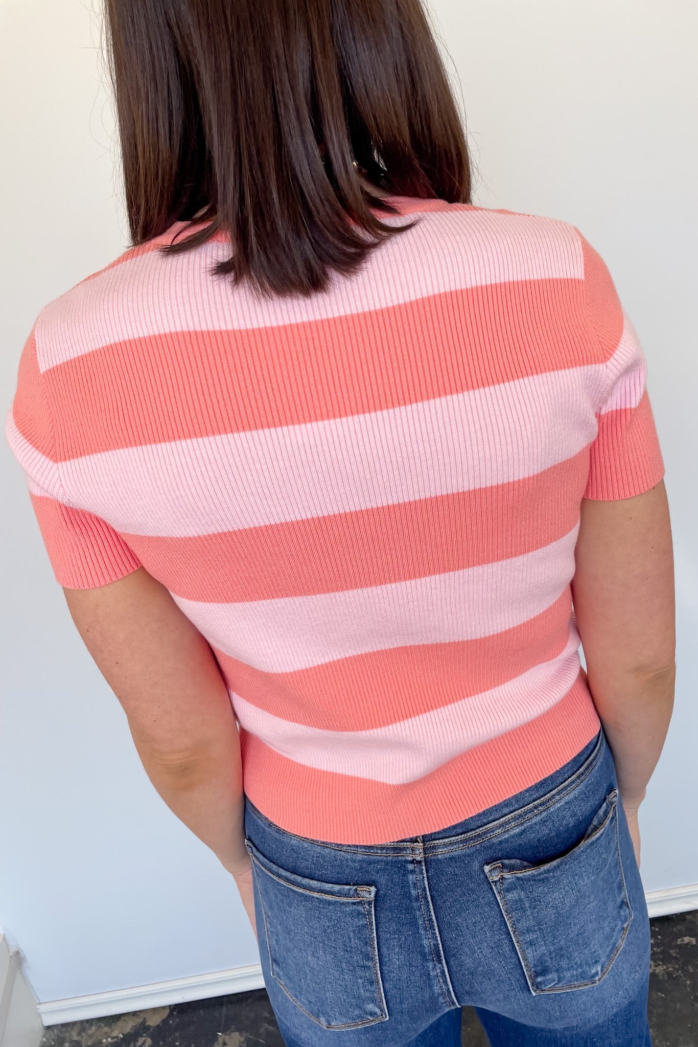 Pink and coral toned striped sweater. High neckline. Slightly cropped fit. Short sleeve style.