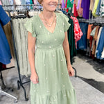 Olive green midi length dress with embroidered flower detail. Smocked top. Short sleeves.