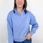 Woman wearing a light blue pullover with a white background