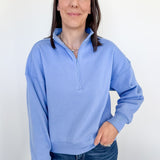 Woman wearing a light blue pullover with a white background
