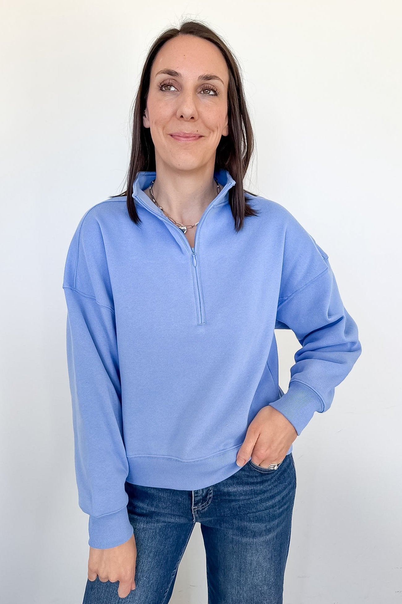 Woman wearing a light blue pullover with a white background