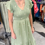 Olive green midi length dress with embroidered flower detail. Smocked top. Short sleeves.